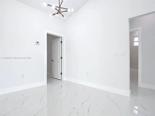 an empty room with a ceiling fan and carpet