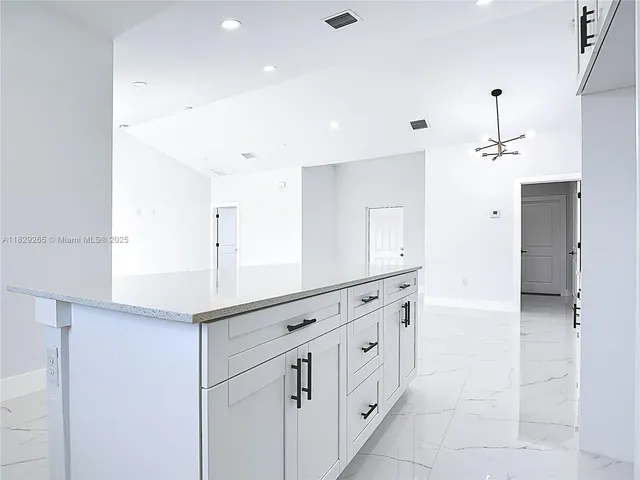 a kitchen with cabinets appliances a sink and a counter top space