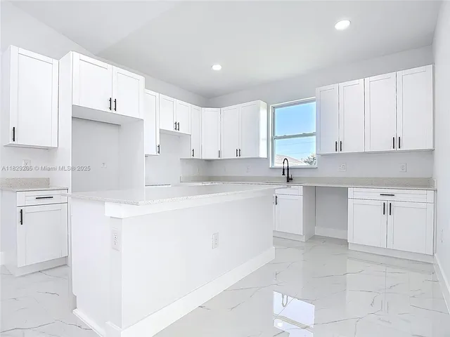 a view of an empty room with a kitchen