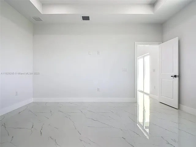 an empty room with a ceiling fan and carpet