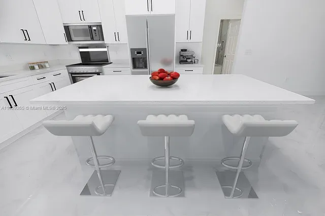 a kitchen with stainless steel appliances a table and chairs in it