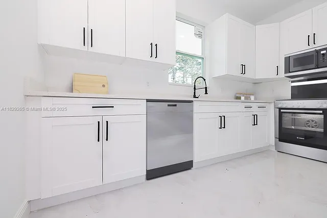 a kitchen with white cabinets and white appliances