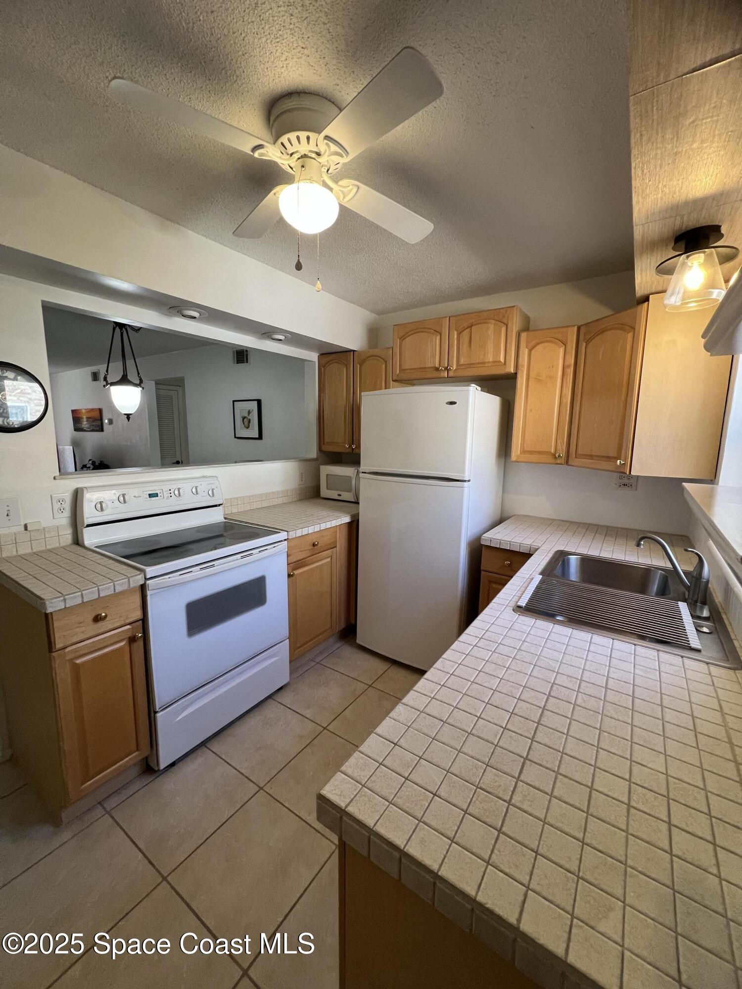 190 East Olmstead Drive, Unit E5 Titusville, FL 32780 - Photo 11 of 26 a kitchen with a sink appliances and cabinets