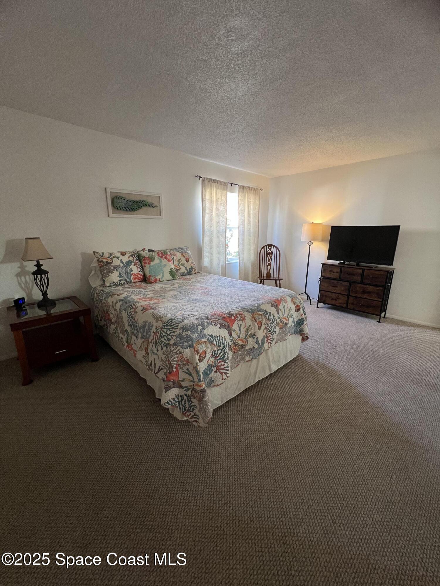 190 East Olmstead Drive, Unit E5 Titusville, FL 32780 - Photo 15 of 26 a bedroom with a bed and dresser