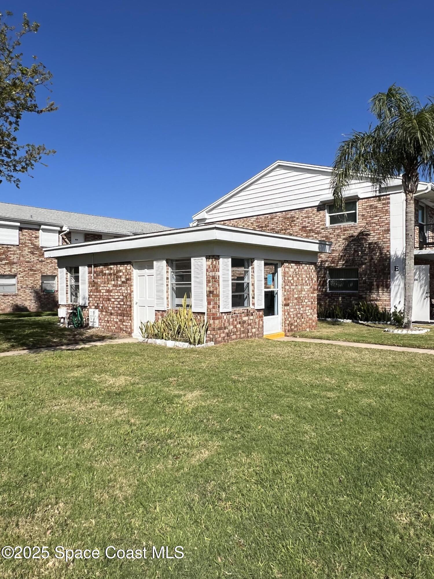190 East Olmstead Drive, Unit E5 Titusville, FL 32780 - Photo 18 of 26 a front view of a house with a garden