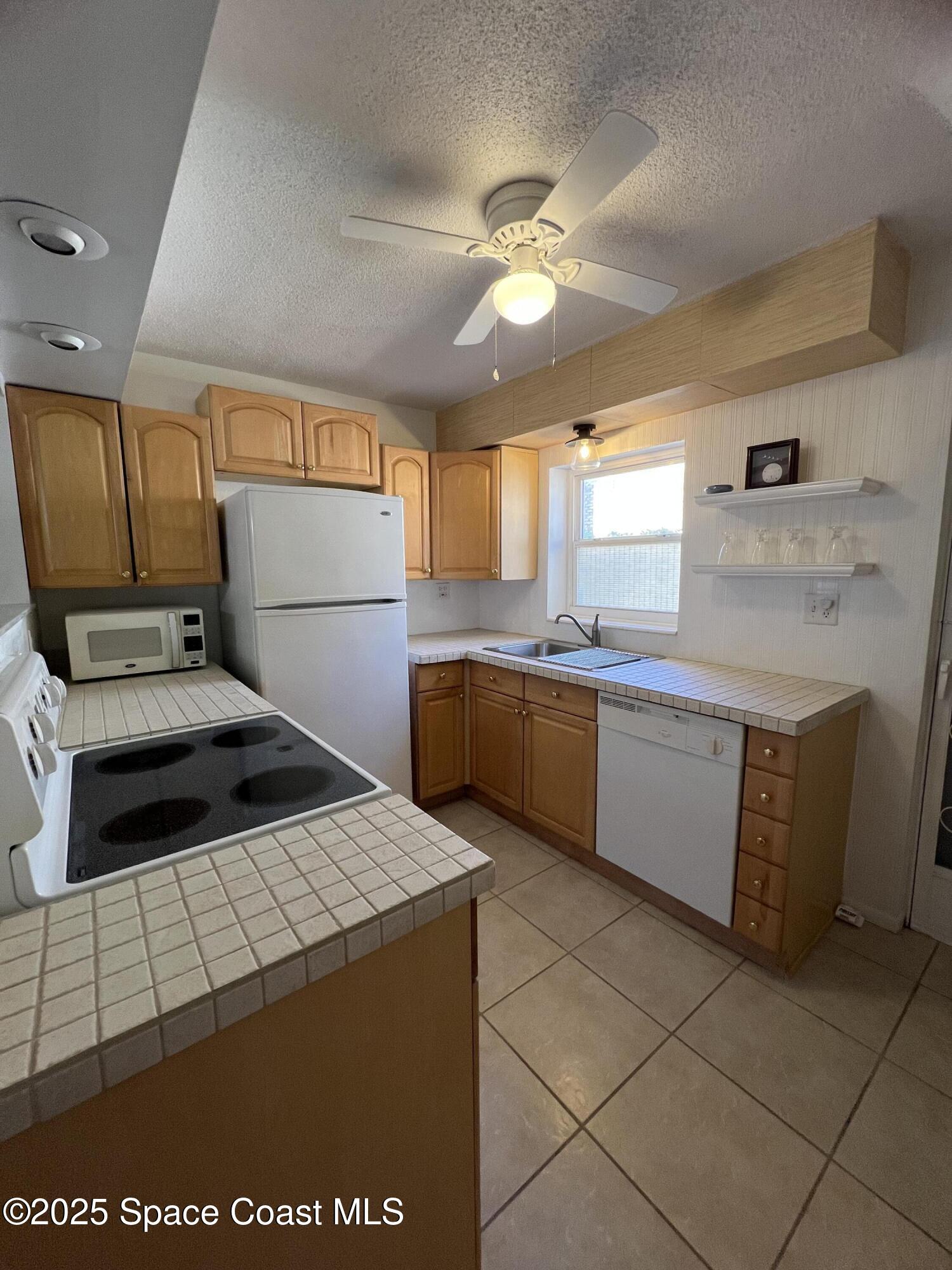 190 East Olmstead Drive, Unit E5 Titusville, FL 32780 - Photo 10 of 26 a kitchen with a cabinets and appliances
