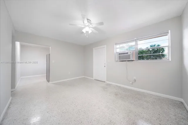 an empty room with windows and fan