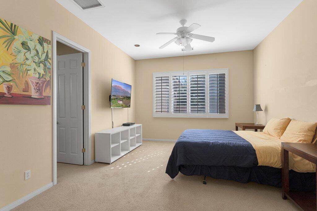8 MacBeth Court Rancho Mirage, CA 92270 - Photo 18 of 46 a spacious bedroom with a bed and a chandelier