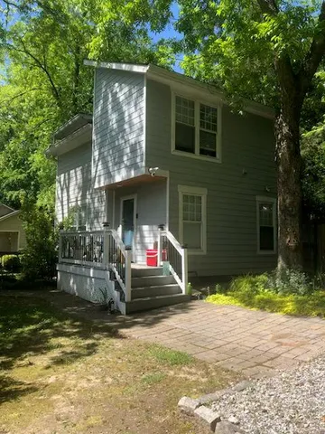 a view of a house with a yard and tree