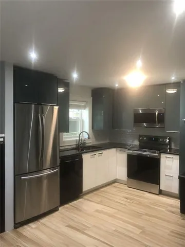 a kitchen with stainless steel appliances granite countertop a refrigerator a sink a stove and oven