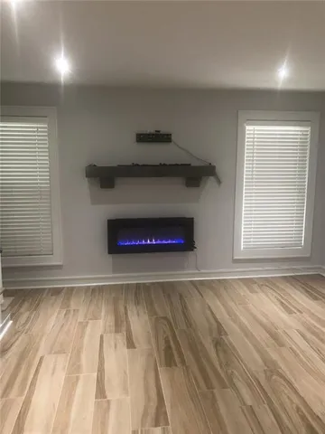 a view of empty room with wooden floor and fireplace