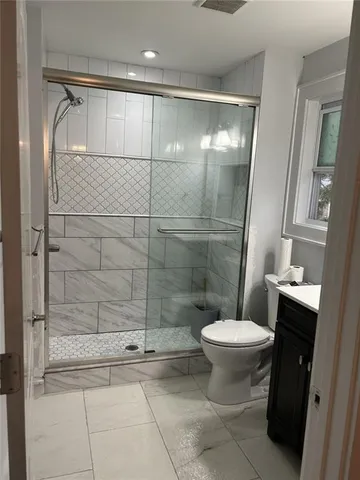 a bathroom with a toilet and a shower