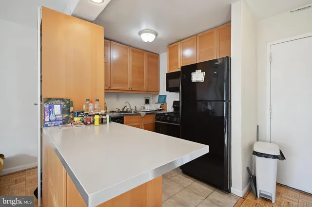 a kitchen with a refrigerator a sink and cabinets
