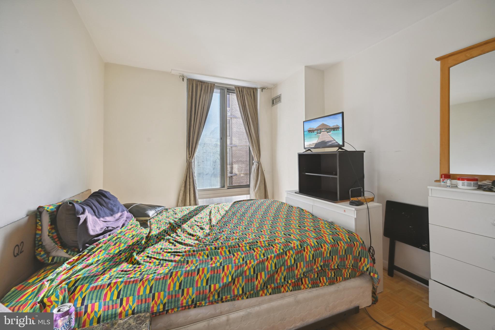 950 25th Street Northwest, Unit 814N Washington, DC 20037 - Photo 14 of 44 a bedroom with a bed and a flat tv screen on a dresser