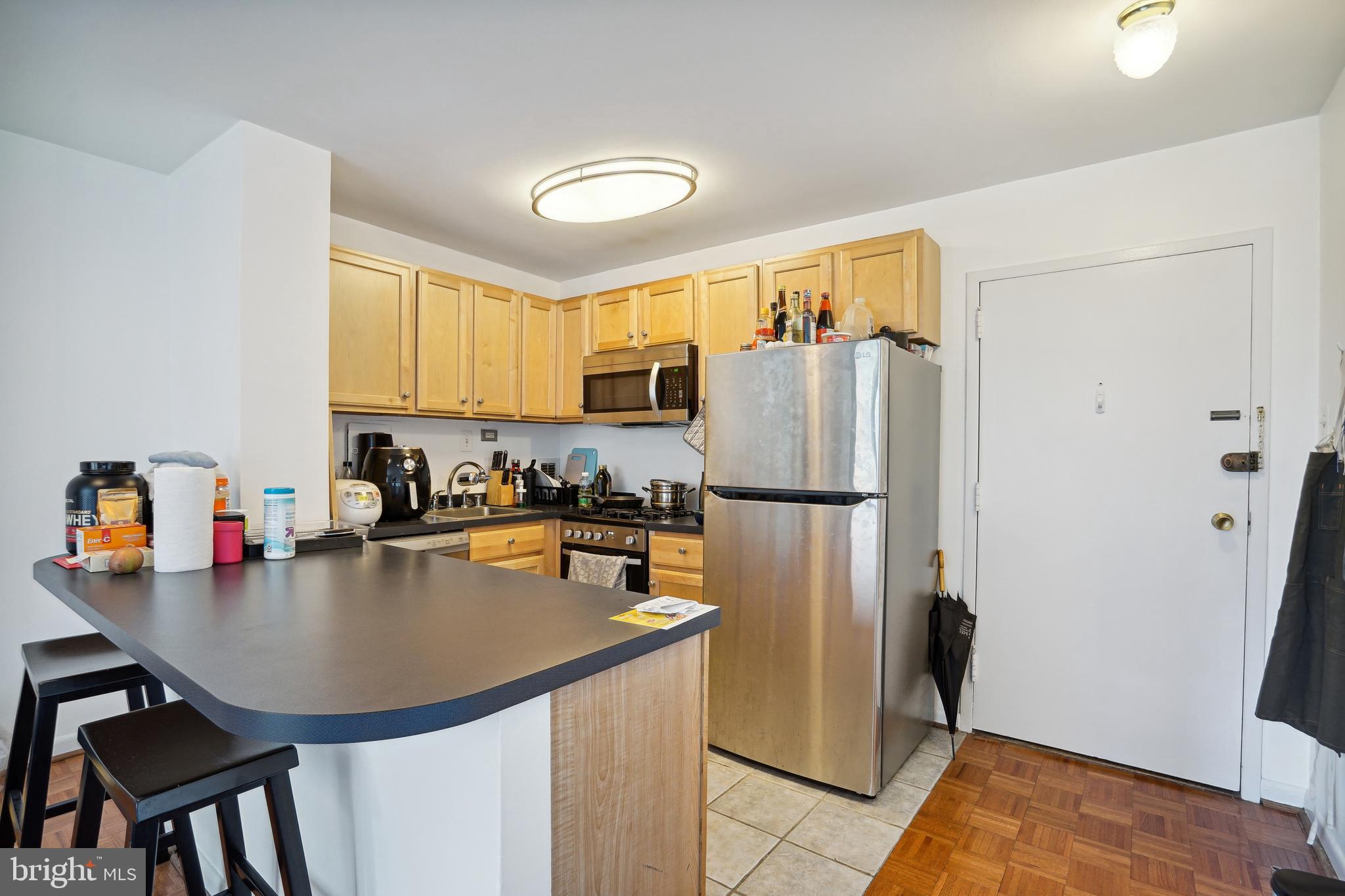 950 25th Street Northwest, Unit 814N Washington, DC 20037 - Photo 34 of 44 a kitchen with stainless steel appliances granite countertop a refrigerator a sink a stove and island
