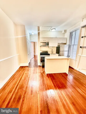 a view of kitchen with wooden floor and electronic appliances