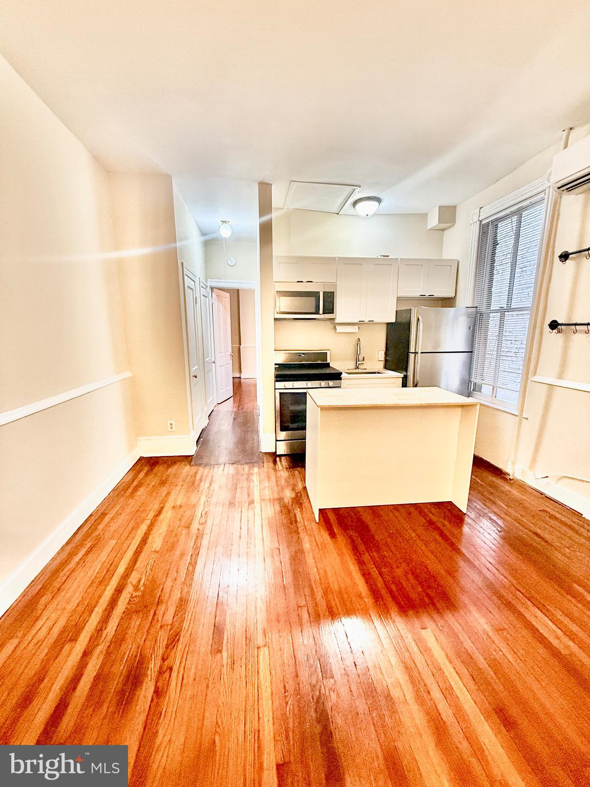 a view of kitchen with wooden floor and electronic appliances