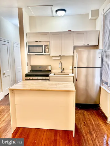 a kitchen with a refrigerator and a stove
