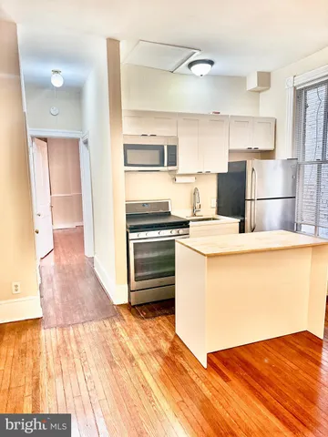 a kitchen with granite countertop a refrigerator and a stove top oven