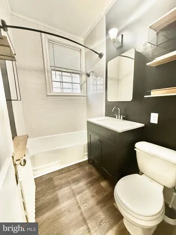 a bathroom with a sink a toilet a mirror and bathtub