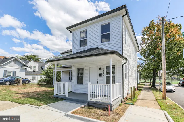 a view of a white house with a yard and plants