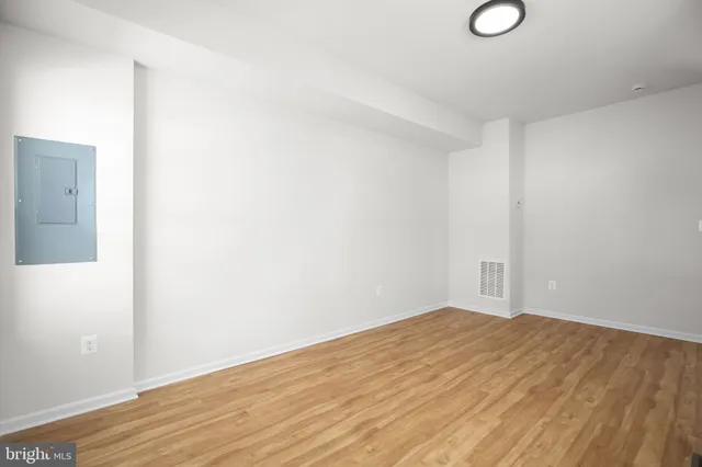 a view of empty room with wooden floor