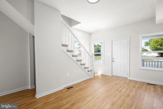 a view of a hallway with wooden floor and staircase