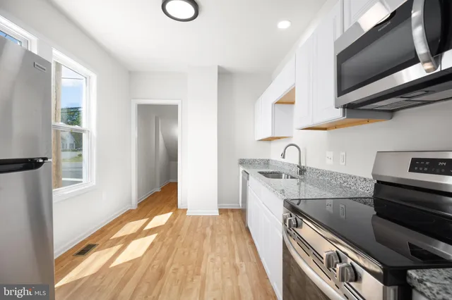 a kitchen with stainless steel appliances granite countertop a sink and a stove