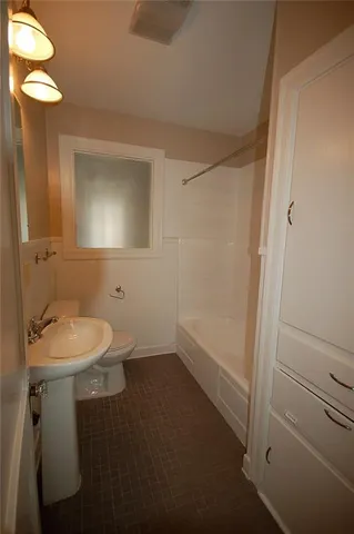 a bathroom with a sink a toilet and mirror
