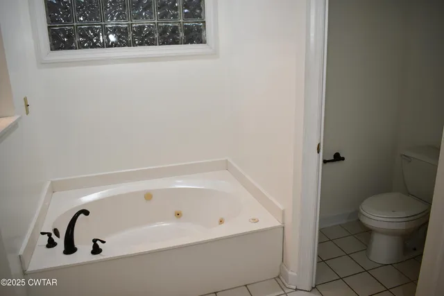 an empty room with a window and a chandelier fan