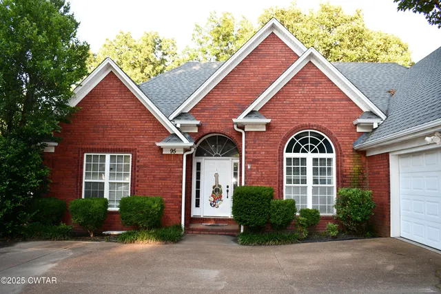 an empty room with wooden floor a chandelier and windows