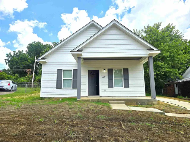 a view of a white house with a yard