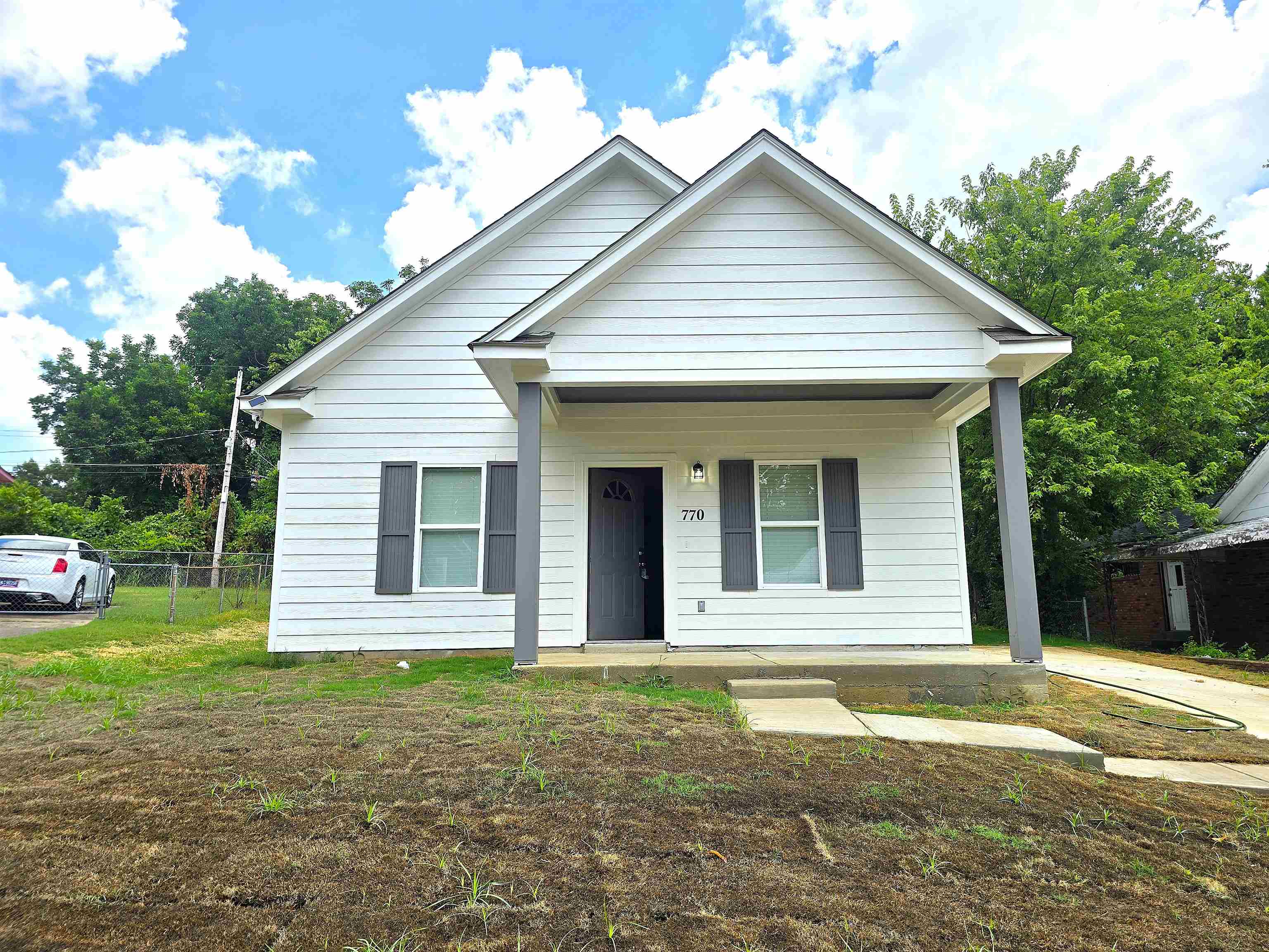 a view of a white house with a yard