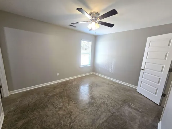 an empty room with windows and fan
