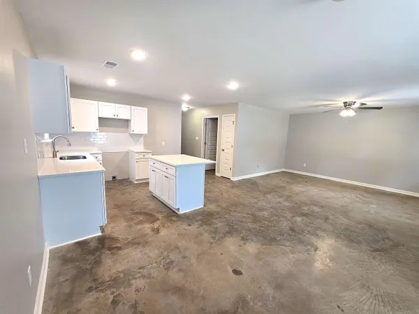a view of a kitchen with a sink and dishwasher a refrigerator with white cabinets