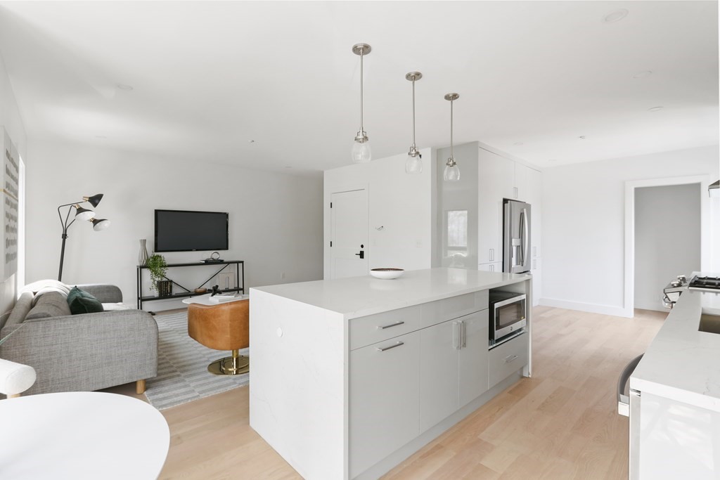 44 Cottage Street, Unit 2 Boston, MA 02128 - Photo 4 of 18 a living room with furniture a flat screen tv and a large window