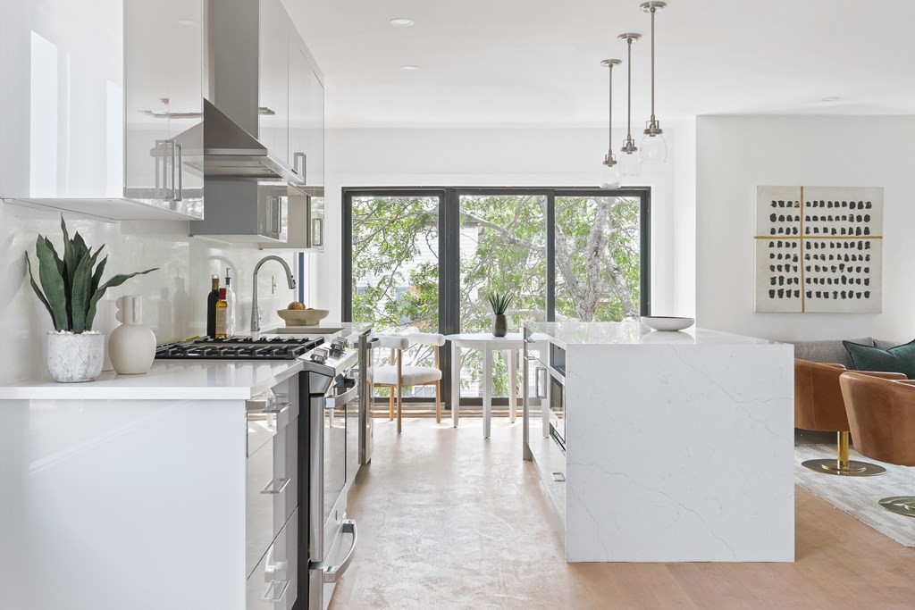 44 Cottage Street, Unit 2 Boston, MA 02128 - Photo 7 of 18 a kitchen with stainless steel appliances a white table chairs and a large window