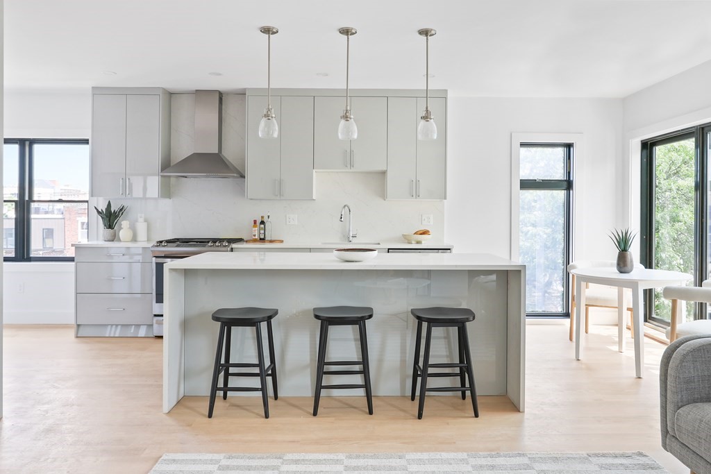 44 Cottage Street, Unit 2 Boston, MA 02128 - Photo 9 of 18 a kitchen with stainless steel appliances granite countertop a table chairs sink and cabinets