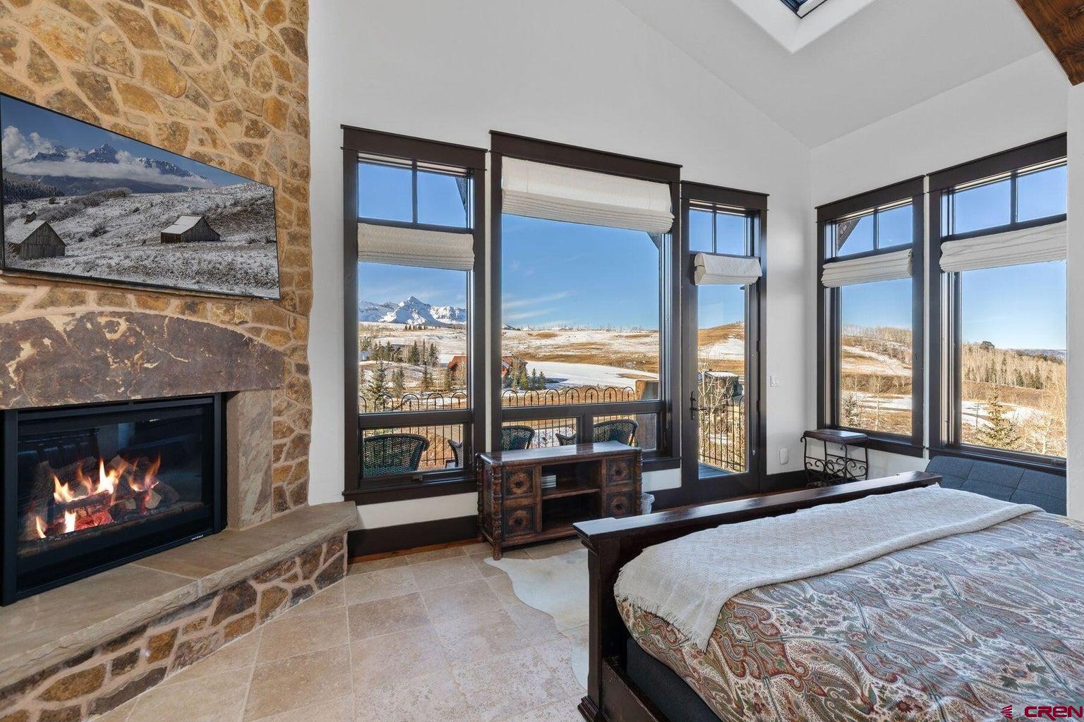 172 Adams Ranch Road Mountain Village, CO 81435 - Photo 11 of 29 a bedroom with a bed and a fireplace