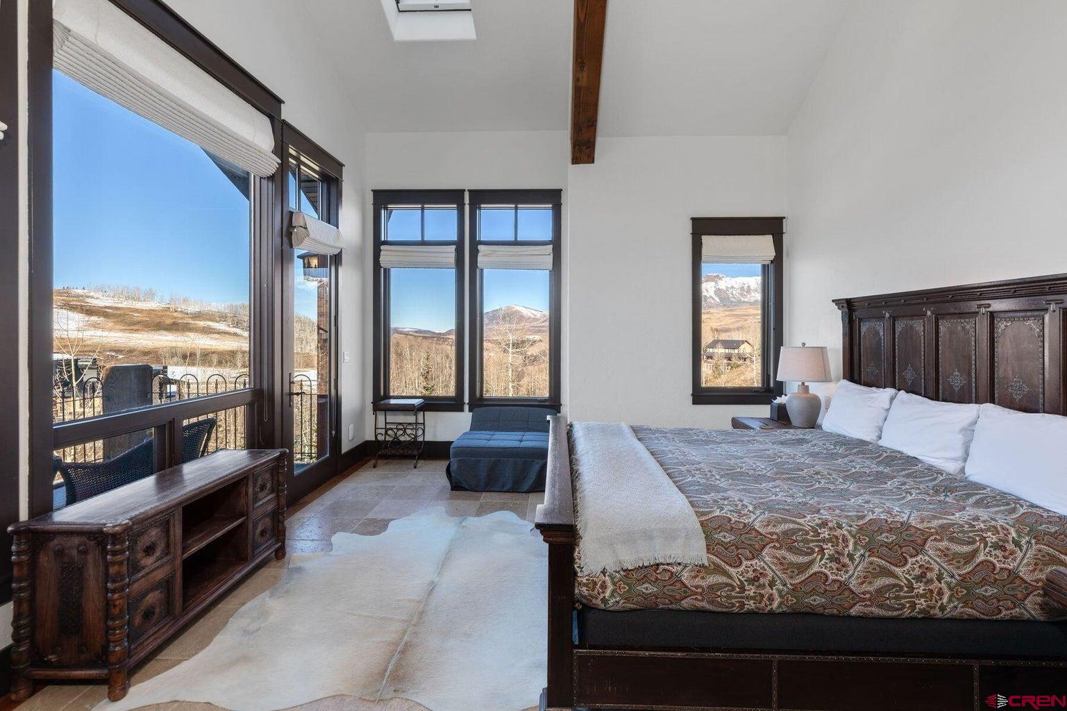 172 Adams Ranch Road Mountain Village, CO 81435 - Photo 12 of 29 a bedroom with a large bed and a balcony view