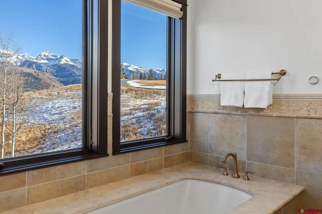a bathroom with a sink and a large mirror next to a window