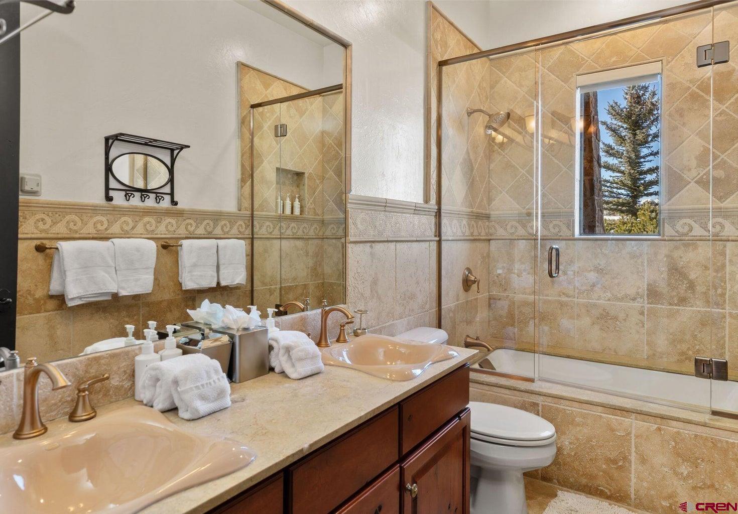 172 Adams Ranch Road Mountain Village, CO 81435 - Photo 26 of 29 a bathroom with a granite countertop sink mirror toilet and bathtub