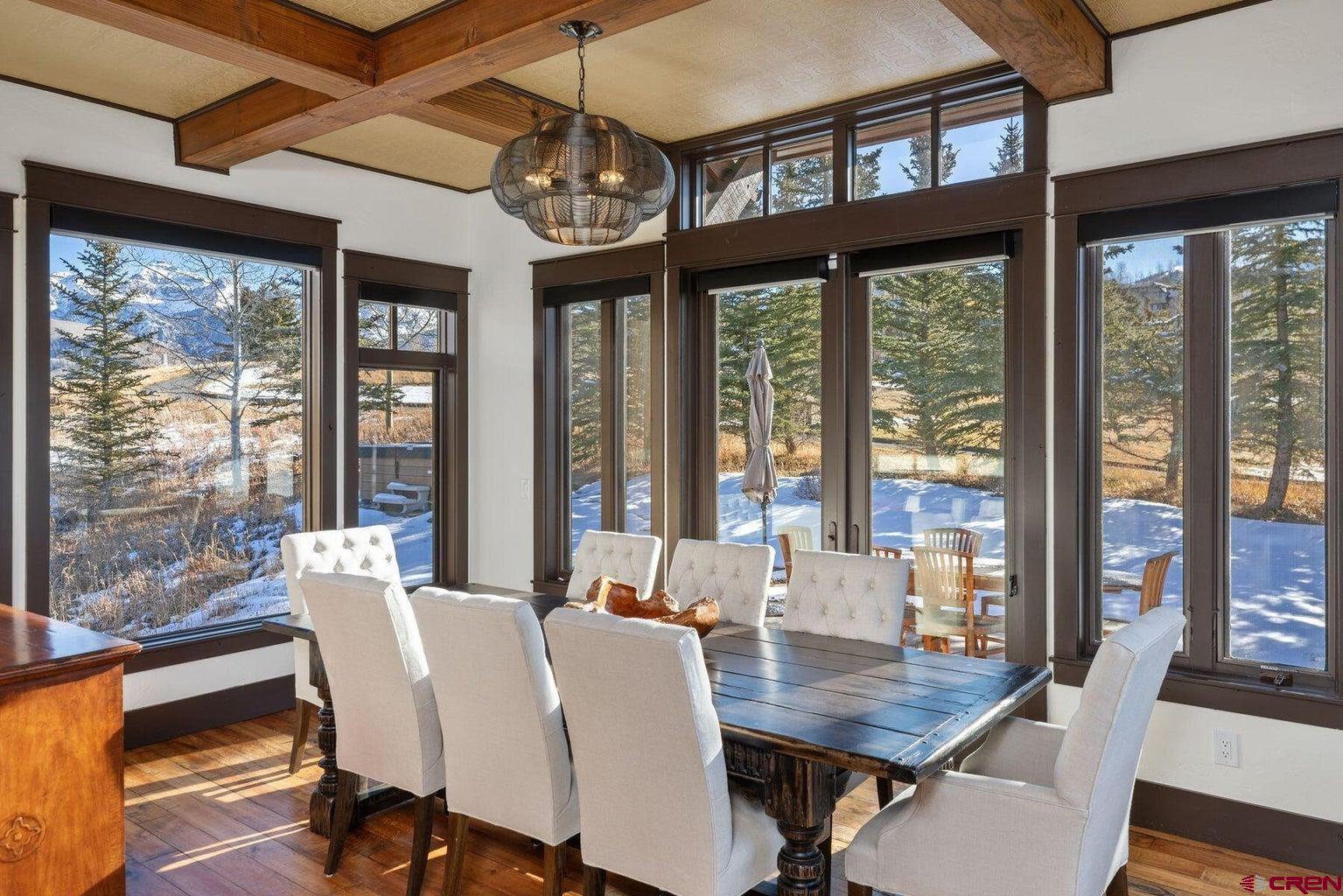 172 Adams Ranch Road Mountain Village, CO 81435 - Photo 9 of 29 a view of a dining room with furniture large windows and wooden floor