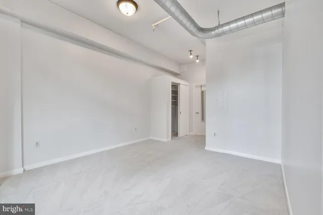 an empty room with windows and closet