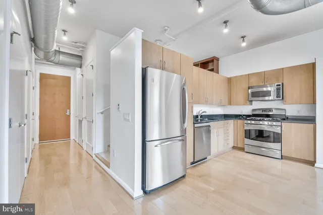 a kitchen with stainless steel appliances a refrigerator sink and microwave