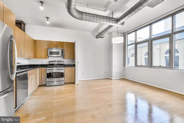 a kitchen with stainless steel appliances kitchen island granite countertop a stove and a refrigerator