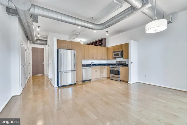 a kitchen with stainless steel appliances a refrigerator and a stove top oven