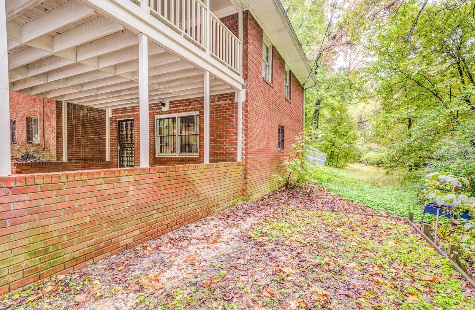 2725 Covington Pike Memphis, TN 38128 - Photo 22 of 26 View of side of property featuring brick siding, a patio area, and a balcony
