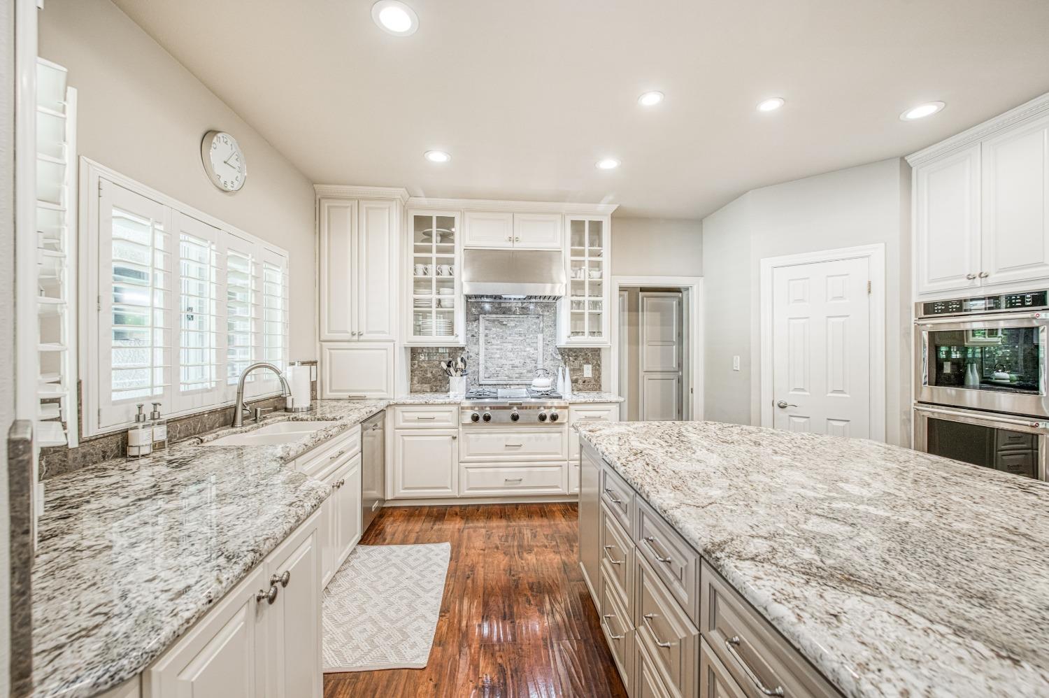 692 East Blue Ridge Road Fresno, CA 93725 - Photo 26 of 68 a large kitchen with kitchen island a large counter space a sink appliances and cabinets