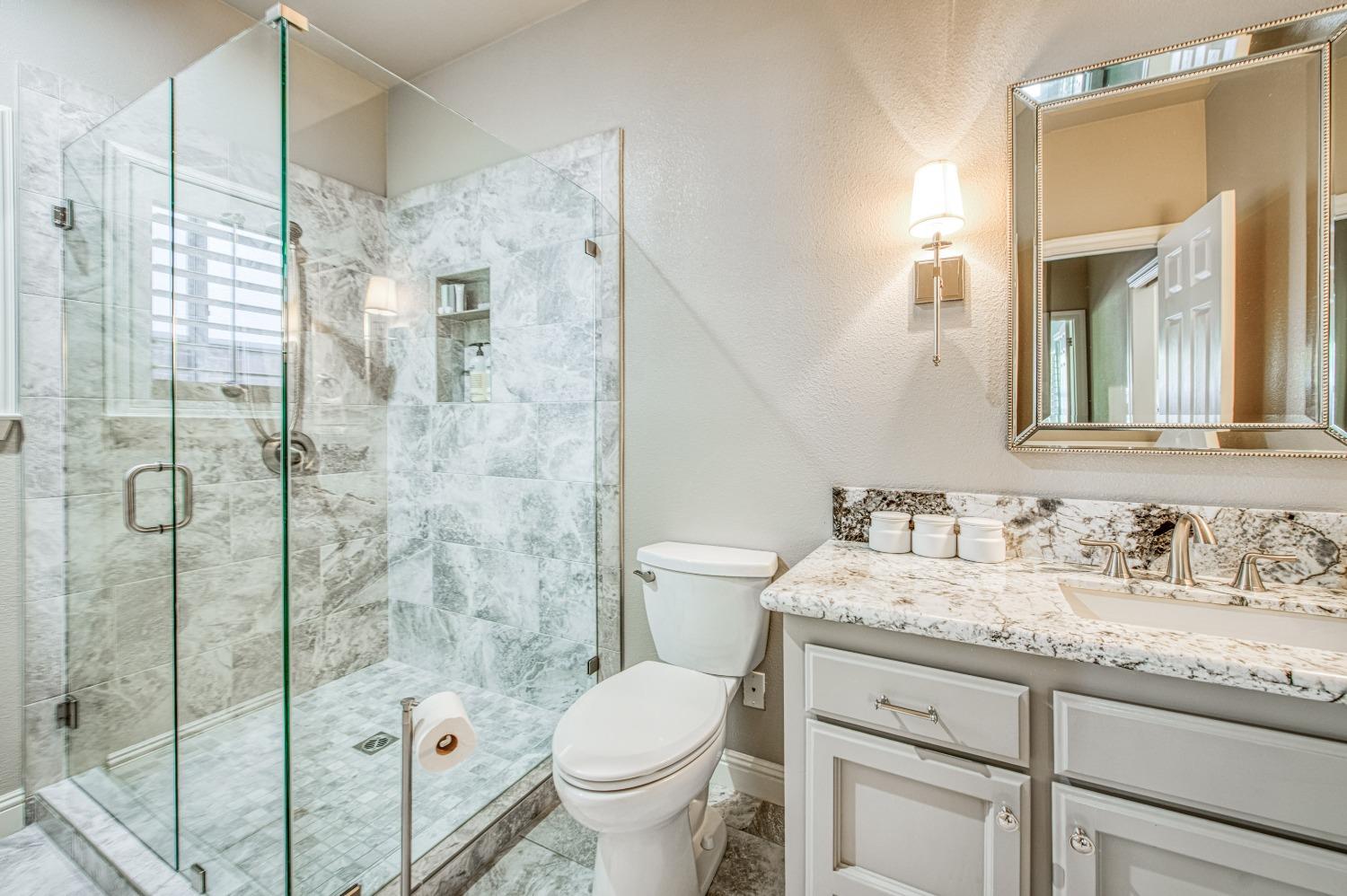 692 East Blue Ridge Road Fresno, CA 93725 - Photo 43 of 68 a bathroom with a granite countertop sink toilet and shower
